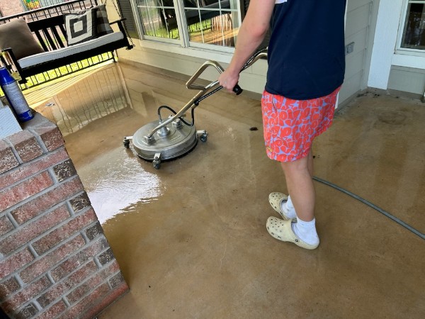 Crew pressure washing a concrete patio
